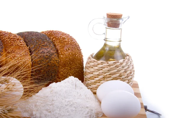 Свежий хлеб, яйца, мука и масло на деревянной доске — стоковое фото