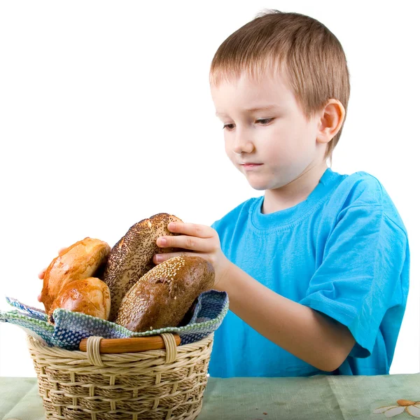 Menino sentado à mesa com pão — Fotografia de Stock