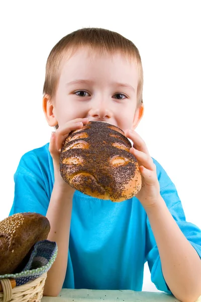 Мальчик сидит за столом с хлебом — стоковое фото