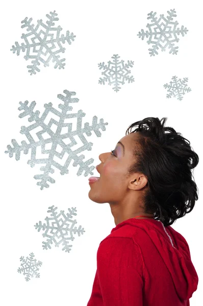 Eine schwarze Frau fängt Schneeflocken — Stockfoto