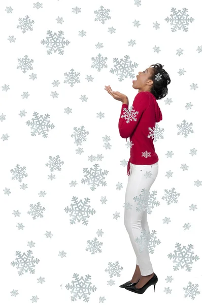 En svart kvinna fånga snöflingor — Stockfoto