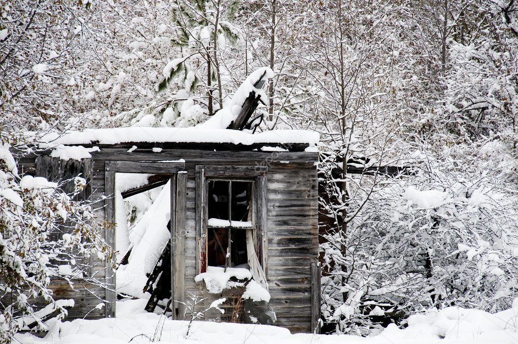 Ghost image in the window of an old abandoned collapsed building covered in a winter snow storm
