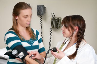 A woman doctor checking a patient blood pressure clipart