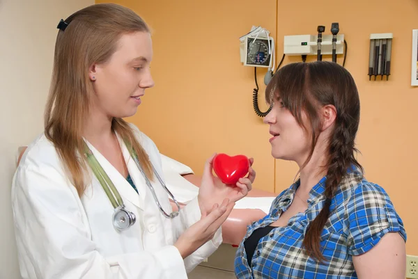 Bir Kadın Hasta Konuşurken Kırmızı Bir Kalp Tutan Bir Kadın — Stok fotoğraf