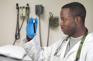 A black man African American doctor holding a test tube vial sample of blood