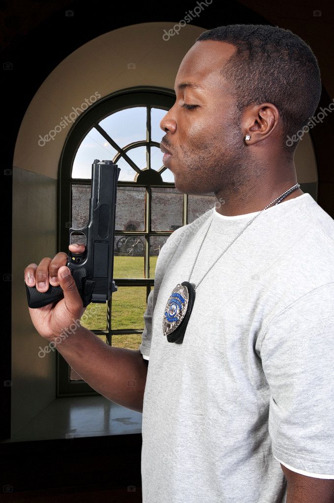 A black African American police detective man on the job with a gun