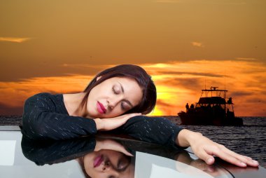 A beautiful hispanic woman dreaming about a boat sailing on the ocean at sunset. clipart
