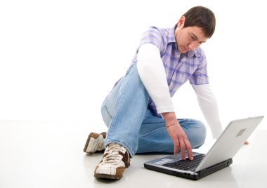 dizüstü bilgisayar ile genç adam oturuyor. öğrenci. stüdyo çekimi üzerine beyaz