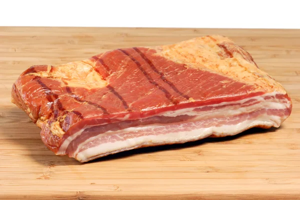 Bacon em uma placa de cozinha — Fotografia de Stock
