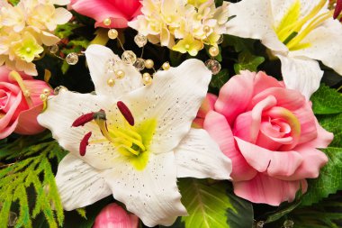 Close-up of bouquet of artificial flowers with lily on foreground clipart