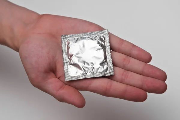 Condom on male palm — Stock Photo, Image
