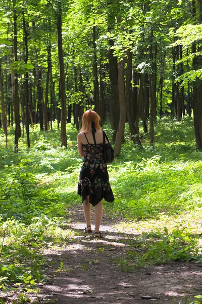 Рыжеволосая женщина, гуляющая по лесу — стоковое фото