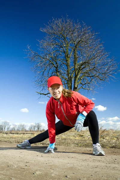 La mujer se estira después de cruzar el país corriendo —  Fotos de Stock