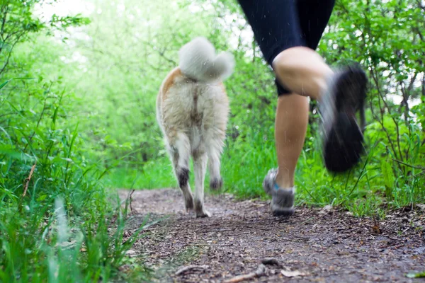 Femme course cross-country avec chien — Photo