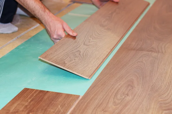 安装新的强化木地板的工人 — 图库照片