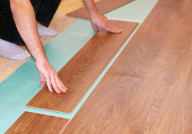 Worker installing new laminate flooring clipart