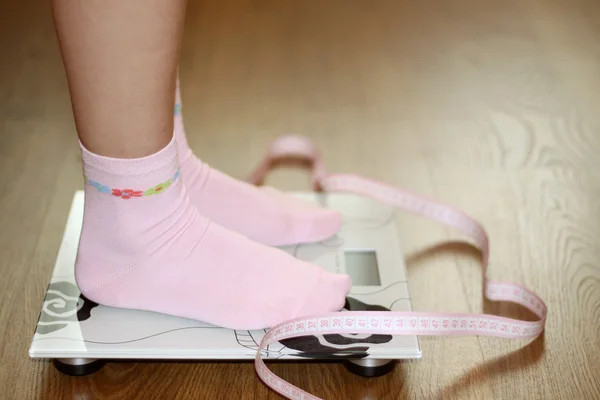 Mulher em escala com fita métrica rosa, dieta — Fotografia de Stock