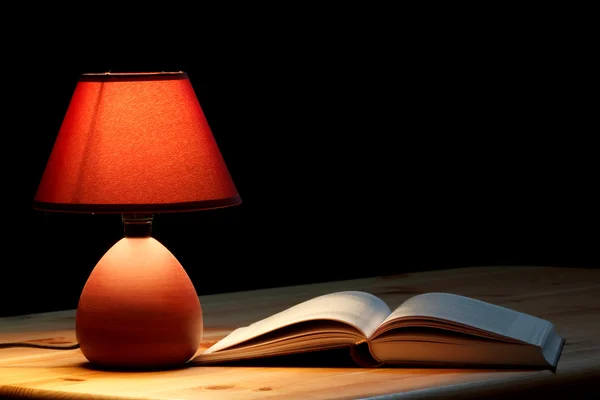 Lâmpada iluminando um livro — Fotografia de Stock