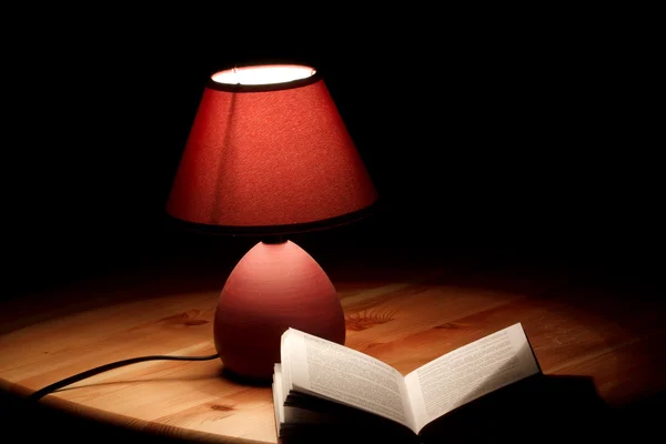 Λάμπα Φωτίζει Ένα Βιβλίο Για Ξύλινο Τραπέζι Εικόνα Αρχείου