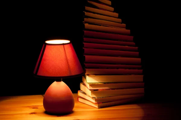 Lampe éclairant les livres — Photo