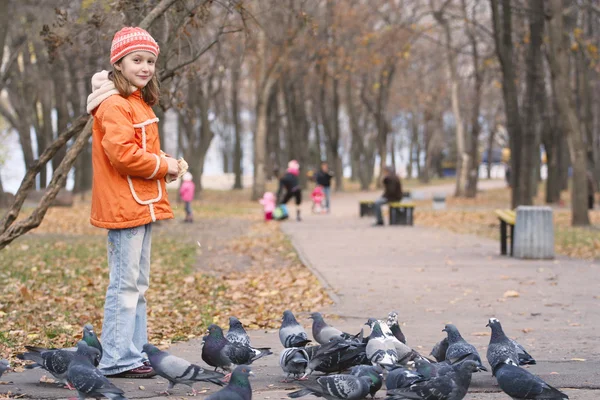 Chica alimentando a una paloma —  Fotos de Stock