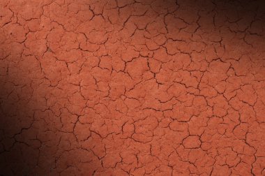 Cracked red textured surface lit diagonally clipart