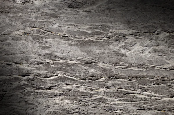 Risse an der Felsoberfläche schräg beleuchtet — Stockfoto