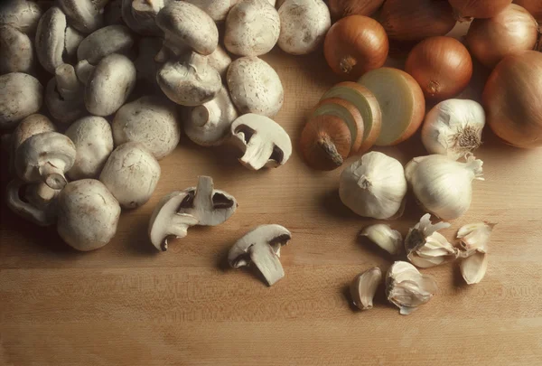 stock image Mushrooms, onions and garlic on a butcherblock surface