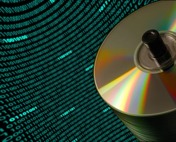 Pila di dischi CD / DVD contro un campo curvo di codice binario — Foto Stock