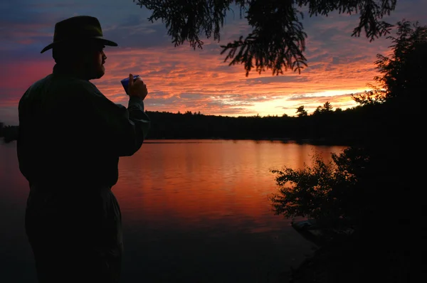 Camper watching sunset sunrise over lake — Stock Photo, Image