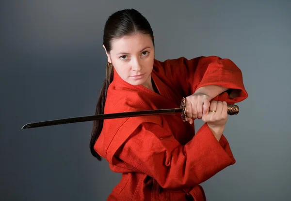 Молода дівчина в червоному кімоно з самураєм — стокове фото