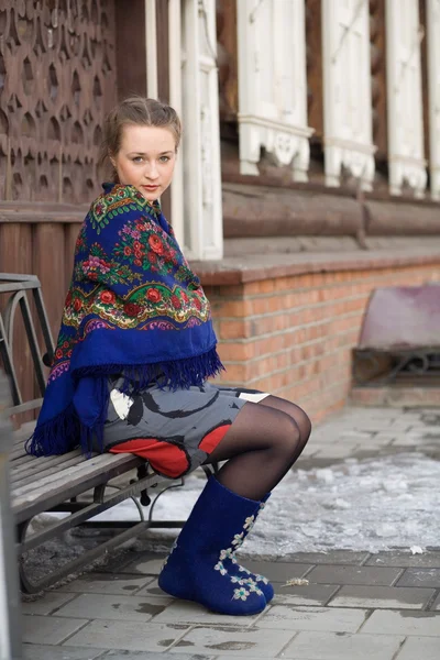Russisches Mädchen auf dem Hintergrund eines Holzhauses. — Stockfoto