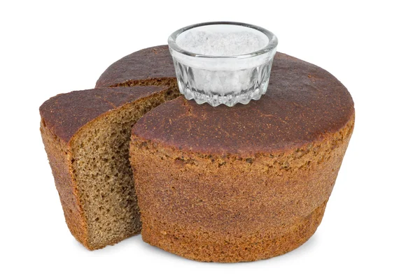 Cut loaf of round rye bread and salt jar — Stock Photo, Image