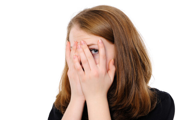 Yong woman hide her face through fingers, on a white background
