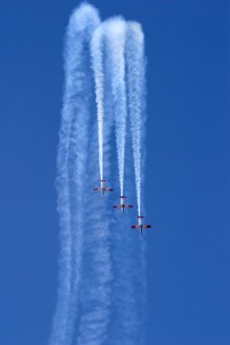 Three planes performing a synchronized flying display during an aerobatic show clipart