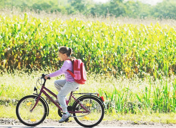 Skolflicka reser till skolan på cykel — Stockfoto