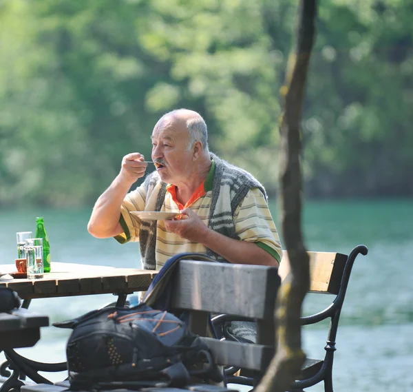 Starszy mężczyzna jeść przygotowują doskonałe na świeżym powietrzu restauracja — Zdjęcie stockowe