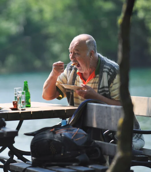 Senior man eat desser at outdoor restaurant — Stock Photo, Image