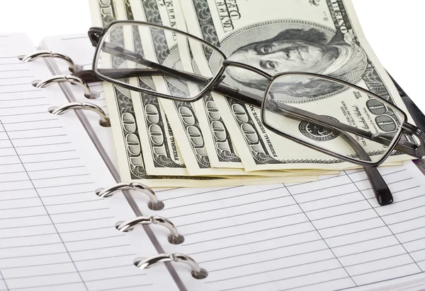 Opened notebook, dollars and glasses — Stock Photo, Image