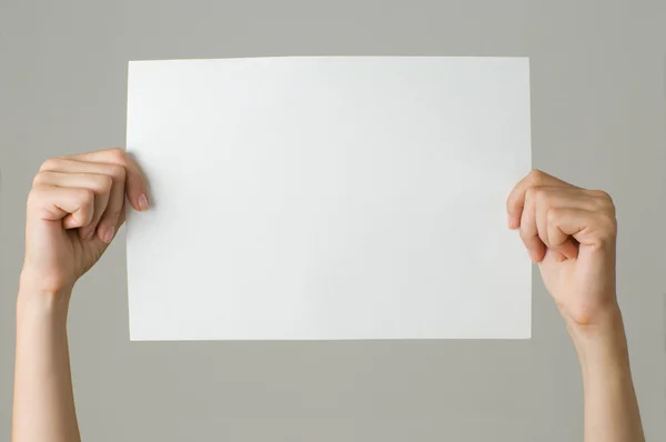 灰色に分離された空白の紙を持つ女性 — ストック写真
