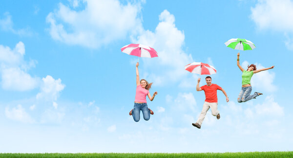 Young friends jumping with umbrellas