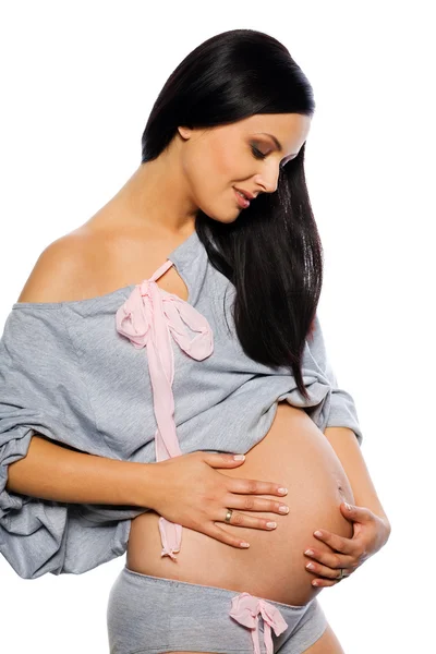 Pregnant woman holding exposed belly — Stock Photo, Image