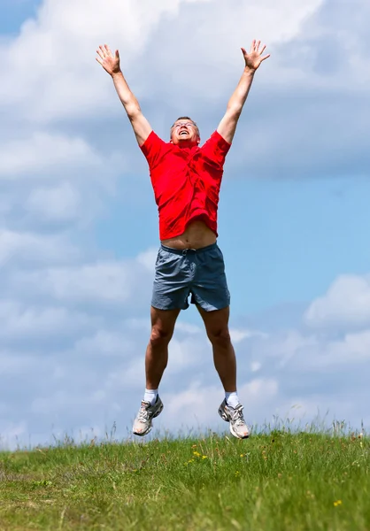 おかしい青年が分野で高いジャンプ — ストック写真