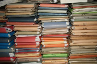 Multicolored cardboard files containing loads of paperwork clipart