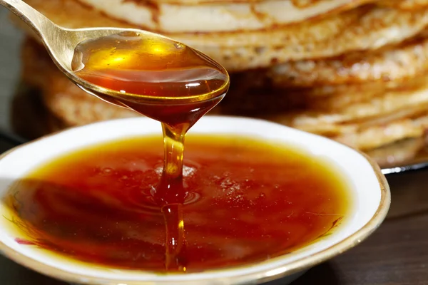Esslöffel Honig auf dem Hintergrund von Pfannkuchen — Stockfoto