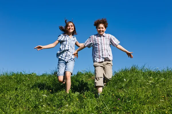 Девочка и мальчик бегут на открытом воздухе — стоковое фото