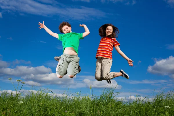 Girl and boy jumping — Stock Photo, Image