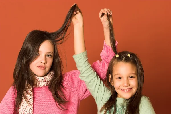 Zwei hübsche Mädchen, die Haare berühren — Stockfoto