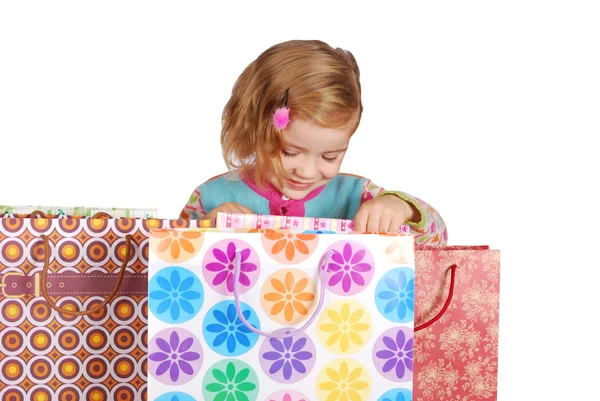 Dziewczynka, patrząc w torby na zakupy — Zdjęcie stockowe