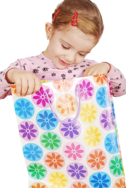 Curious little girl looking in shopping bag — Stock Photo, Image